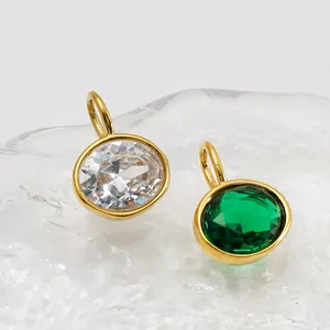 Gros plan détaillé de pendentifs ovales en zircone vert émeraude et blanc plaqué or