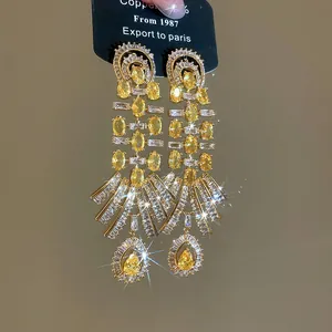 Close-up of vintage palace style 18k gold plated earrings with yellow zircon teardrops