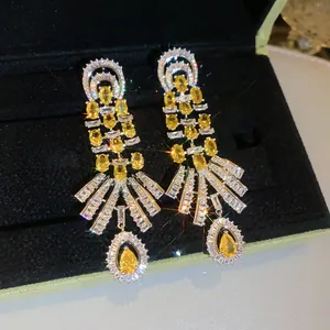 Detailed view of luxury palace style earrings featuring sparkling yellow water drop zircons
