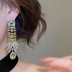 Detailed close-up of vintage palace style earrings with yellow zircon teardrop pendant
