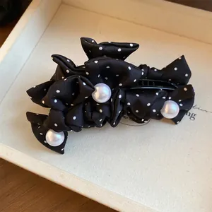 Detailansicht einer schwarzen Stoff-Haarklammer mit Polka Dots und eleganten Perlenverzierungen