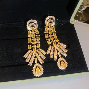 Macro view of vintage style 18k gold plated dangle earrings with yellow zircon crystals