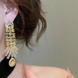 Detailed view of luxury 18k gold plated vintage palace style drop earrings with yellow zircon