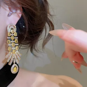 Detail view of 18k gold plated drop earrings with yellow and white cubic zirconia