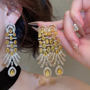 Close-up detail of 18k gold-plated retro palace earrings with sparkling yellow zircon drops.