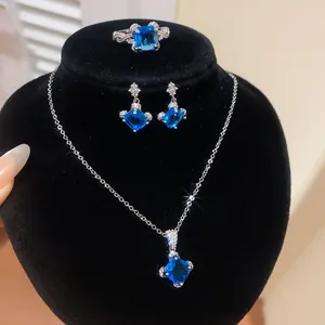 Vue détaillée d'une parure en zircon bleu géométrique avec collier, boucles d'oreilles et bague