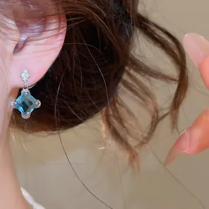 Gros plan détaillé d'une magnifique boucle d'oreille en zircon bleu géométrique