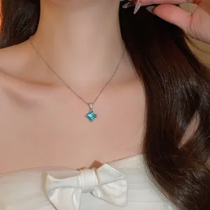 Gros plan d'un collier en argent avec un pendentif étincelant en zircon bleu de forme losange