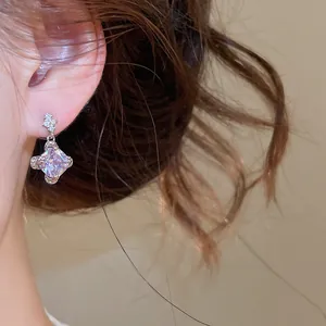 Gros plan d'une boucle d'oreille pendante en zircon géométrique en forme de losange