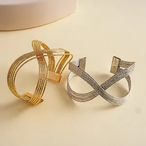 Vue détaillée des bracelets joncs ouverts géométriques plissés en métal doré et argenté.