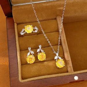 Close-up van een elegante sieradenset met gele zirkonia bloemen, ketting, oorbellen en ring.