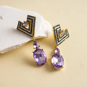 Gros plan de boucles d'oreilles de luxe en forme de cœur avec pierres bleues et mauves