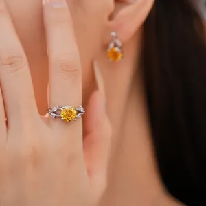 Close-up van elegante zilveren ring en oorbellen set met heldergele bloemgeslepen zirkoon