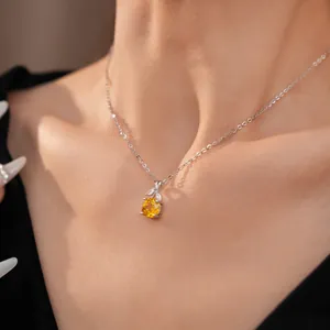 Detailweergave van een elegante zilveren ketting met gele zirkoon bloemenhanger