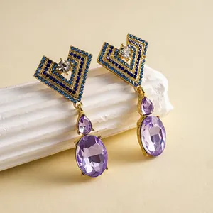Vue détaillée de boucles d'oreilles de luxe en cristal violet et strass bleus chic
