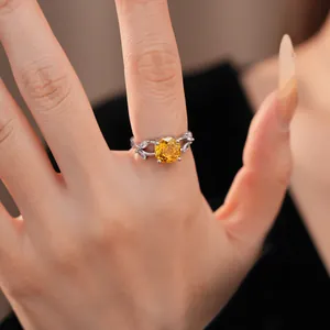 Detailopname van een elegante zilveren ring met een gele zirkoon en fijne bloemendetails