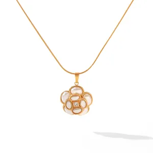Gros plan élégant d'un collier pendentif fleur en acier inoxydable plaqué or 18 carats blanc