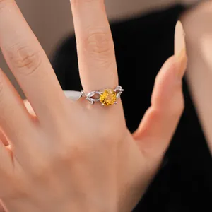 Gedetailleerde opname van een elegante zilveren ring met een sprankelende gele zirkoonsteen