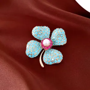 Exquisite flower brooch featuring blue stones and a central pearl on luxury silk background