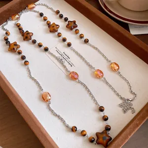 Macro detail of a vintage Maillard style long necklace with star beads in a tray