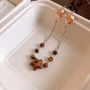 Close-up detail of retro Maillard style beaded necklace with amber beads and star pendant
