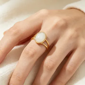 Close-up view of a vintage oval cat's eye stone ring worn on a model's finger