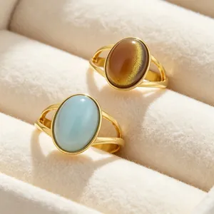 Detail showing light blue and brown oval cat's eye stones in gold stainless steel rings