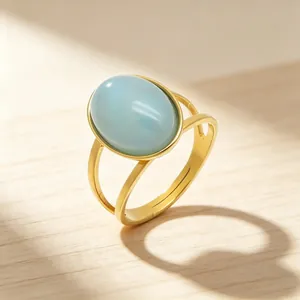 Macro detail of vintage gold stainless steel ring with a smooth oval light blue stone