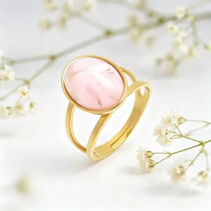 Macro view of a gold stainless steel ring featuring a polished oval pink cat-eye stone.