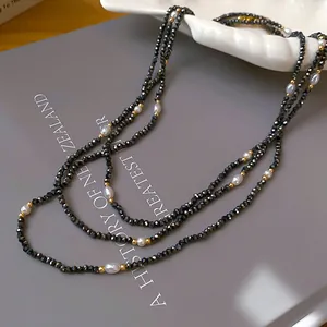 Nahaufnahme einer eleganten mehrlagigen Halskette mit schwarzen Kristallperlen und Perlen