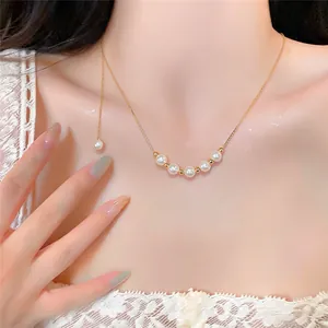 Detailed close-up of a 14k gold-plated pearl necklace worn on a woman's collarbone