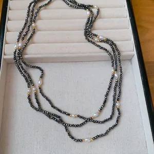 Detailansicht von facettierten schwarzen Kristallperlen und Perlen an einer langen Kette