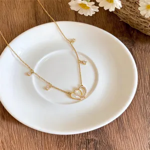 Detailed view of a 14k gold plated heart pendant necklace with shimmering zircons.