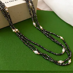 Elegante dreilagige Perlenhalskette mit schwarzen Kristallen und weißen Reisperlen.