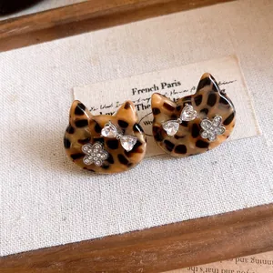 Close-up van de luipaardprint kattenoorbellen met strass bloemdetails en strikjes decoratie