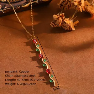 Vue détaillée d'un pendentif tulipe à trois fleurs avec cristaux rouges et verts sur chaîne.