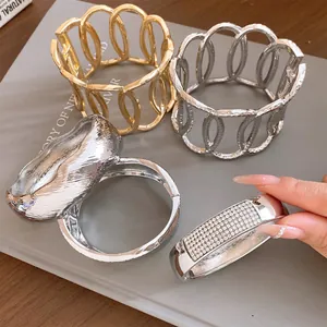 Detail view of assorted silver and gold metal hollow-out bracelets with rhinestone accents