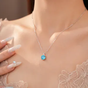 Detailopname van een ronde blauwe zirkoon ketting op het sleutelbeen van het model