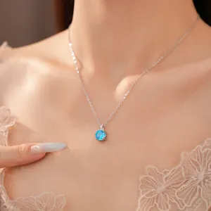 Detailopname van een fonkelende blauwe ronde zircon ketting aan een zilveren ketting