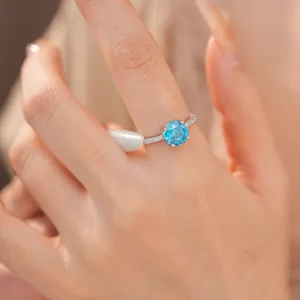Elegante zilveren ring met een ronde facetgeslepen blauwe zirkoon op een vrouwenhand