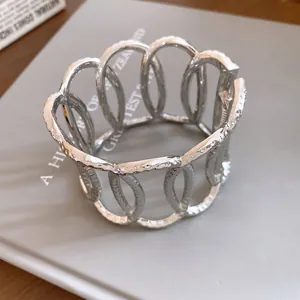Detailed macro shot showing the textured silver metallic oval hollow open cuff bracelet