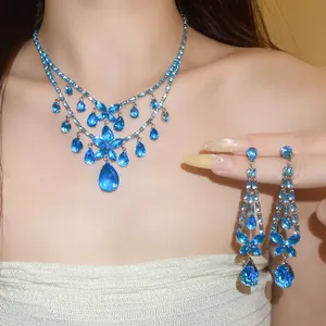 Detailansicht eines eleganten Schmucksets mit blauen Zirkon-Blumen und Tropfenanhängern