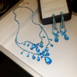 Detailansicht des eleganten blauen Zirkonia-Halsketten- und Ohrring-Sets mit Blumen.