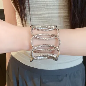 Detail of silver metal hollow oval open cuff bracelet with hammered texture