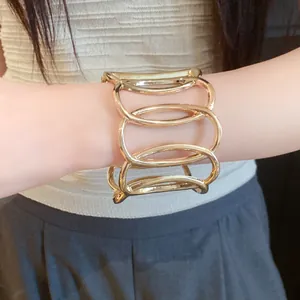 Stylish chunky gold metal cuff bracelet featuring a unique oval hollow openwork design on wrist
