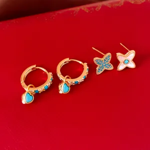 Détail de boucles d'oreilles plaquées or 18 carats avec nacre et pierres bleues