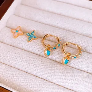 Gros plan de boucles d'oreilles plaquées or avec puces étoiles et anneaux de cœur