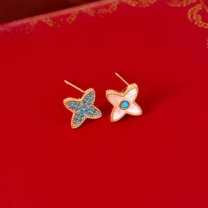 Vue détaillée de boucles d'oreilles fleurs plaquées or 18 carats avec nacre et pierres bleues