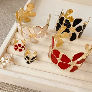 Elegantes Schmuckset aus offenem Ring und Armreif mit gefalteten Blumen und Emaille.
