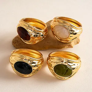 Vista dettagliata di quattro bracciali vintage dorati con inserti in resina ovale stropicciata